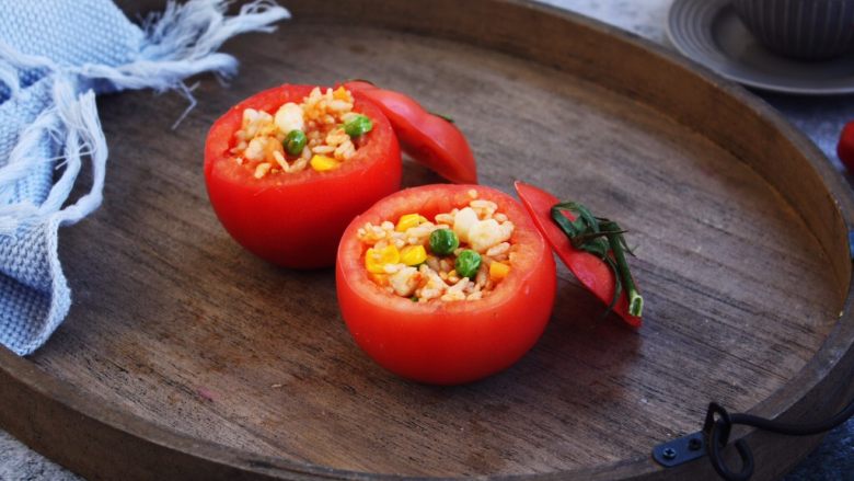 芝士焗番茄鲜虾米饭盅,将炒好的鲜虾米饭放入番茄盅里。
