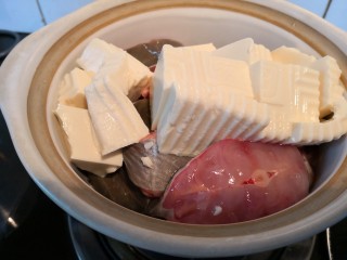 鲶鱼豆腐煲,准备一个砂锅，把腌制好的鲶鱼和豆腐（切成大块）放入砂锅。