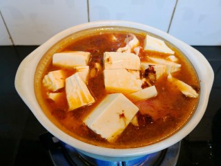 鲶鱼豆腐煲,将煮开的豆瓣酱汤汁倒入砂锅，开大火加盖煮。