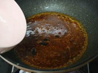 香辣烤鱼,锅中留少许底油，放入一块火锅底料翻炒出红油。加入一大碗水烧开。