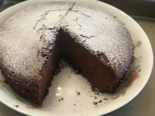 像布朗尼的浓郁巧克力蛋糕(无油全蛋),完成撒上一点糖粉装饰，像下雪一样。切出一块。用来做巧克力蛋糕底也是绝配。