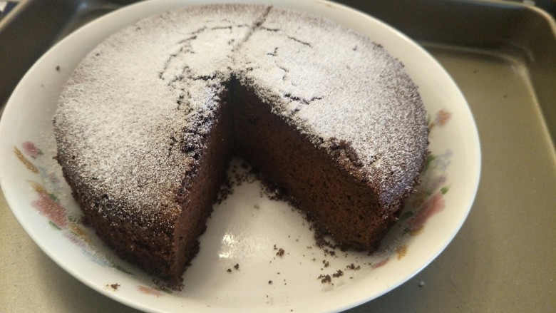像布朗尼的浓郁巧克力蛋糕(无油全蛋),完成撒上一点糖粉装饰，像下雪一样。切出一块。用来做巧克力蛋糕底也是绝配。