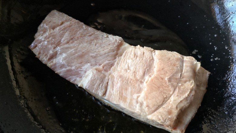 梅菜扣肉,锅中适量油烧热，将猪皮向下，入烧热的油锅里煎。