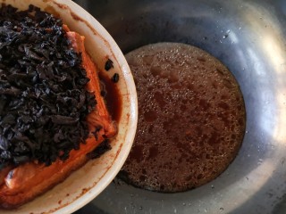 梅菜扣肉,取出蒸好的大碗，放至不烫手后用手端着碗，轻轻蓖出汤汁至锅里。