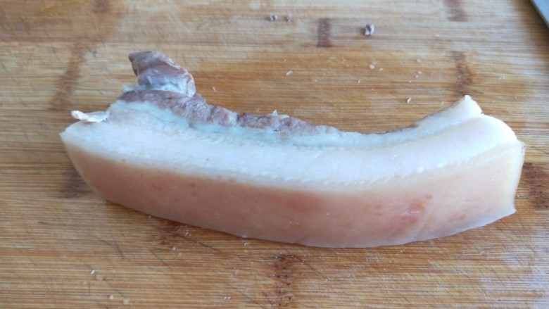 新文美食  炸豆腐 豆腐乳扣肉,五花肉放在案板，中间切一刀然后切成长条形薄片。