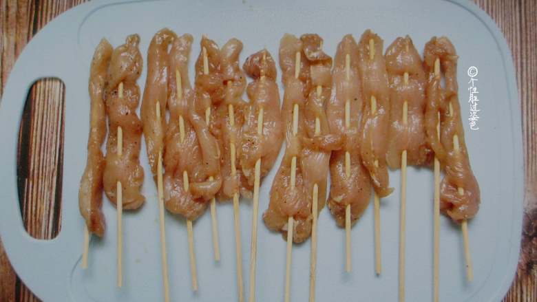 甜辣鸡肉串,将鸡肉穿成串摆盘中。 