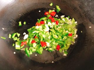清蒸白萝卜-下饭菜,锅里倒入适量食用油，放入小米椒、青尖椒、蒜、葱白，炒1分钟炒香。
