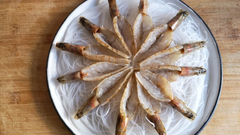蒜蓉粉丝开背虾,将开好背的虾均匀在粉丝上铺开。