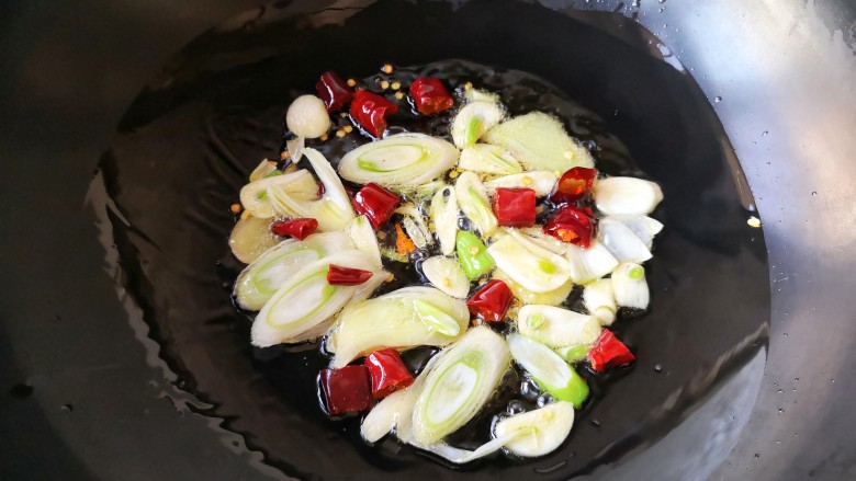 鱼锅片片,锅中适量油下葱姜蒜干辣椒爆出香味。