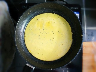 紫薯糯米鸡蛋卷,平底锅加热，并在表面刷一层植物油，倒入鸡蛋糯米粉糊，小火慢煎。