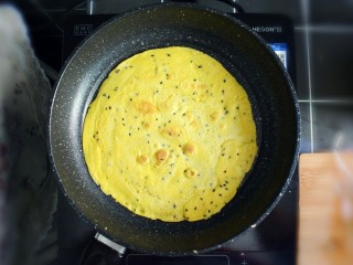 紫薯糯米鸡蛋卷,煎至表面金黄时，翻面，继续煎另外一面。直至两面金黄，关火。