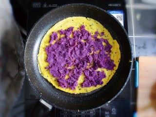 紫薯糯米鸡蛋卷,将紫薯泥平铺在煎好的鸡蛋糯米饼上。