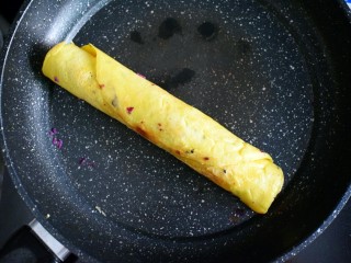 紫薯糯米鸡蛋卷,开小火，将封口处朝下，煎至蛋液凝固，这时，蛋卷的口即被封住了。