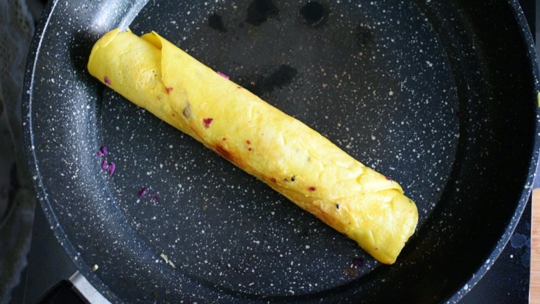 紫薯糯米鸡蛋卷,开小火，将封口处朝下，煎至蛋液凝固，这时，蛋卷的口即被封住了。