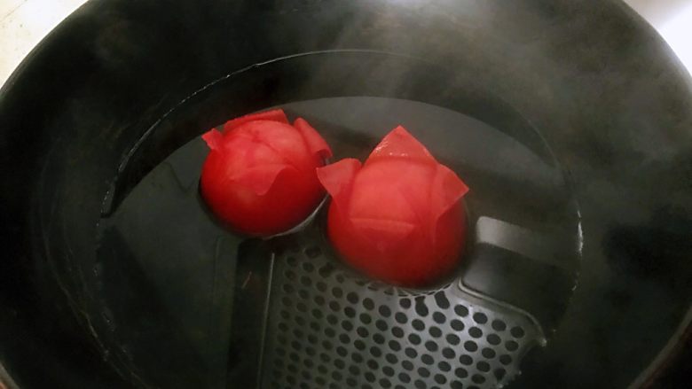 番茄烩金针菇,锅中水烧开后关火放入西红柿，转动，保证每个面都过水，这样皮就很容易去掉了。