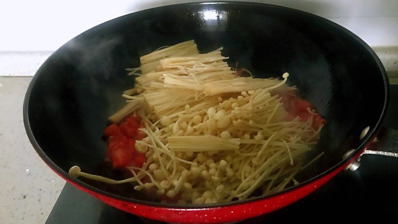 番茄烩金针菇,倒入金针菇，加适量水（吃饭碗的三分之一），翻炒五分钟左右。