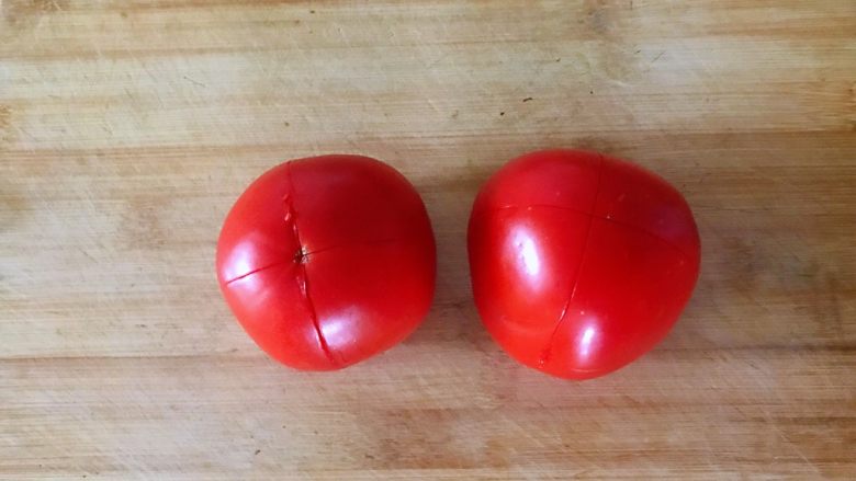 番茄烩金针菇,西红柿顶部用刀轻轻划十字。