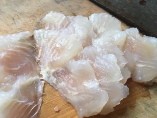 酸菜鱼米线,我喜欢选巴沙鱼，无刺无土腥味。鱼擦干水份放案板上，刀成45度切成薄片。