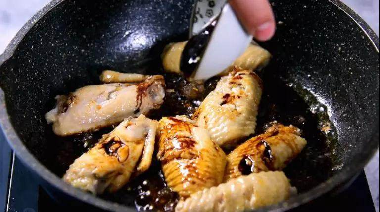 蜜汁鸡翅的家常做法,香嫩口感,抵不住的美味诱惑,倒入冰糖，小火炒化，再倒入酱油、蚝油炒匀上色
