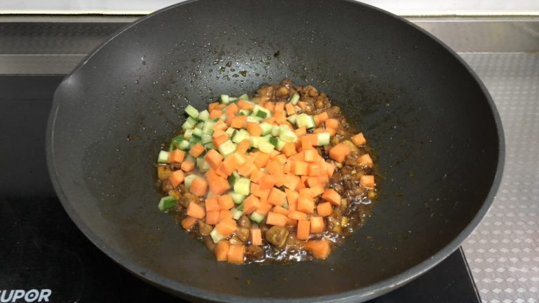 老干妈鸡丁炒饭,倒入胡萝卜和黄瓜丁翻炒均匀