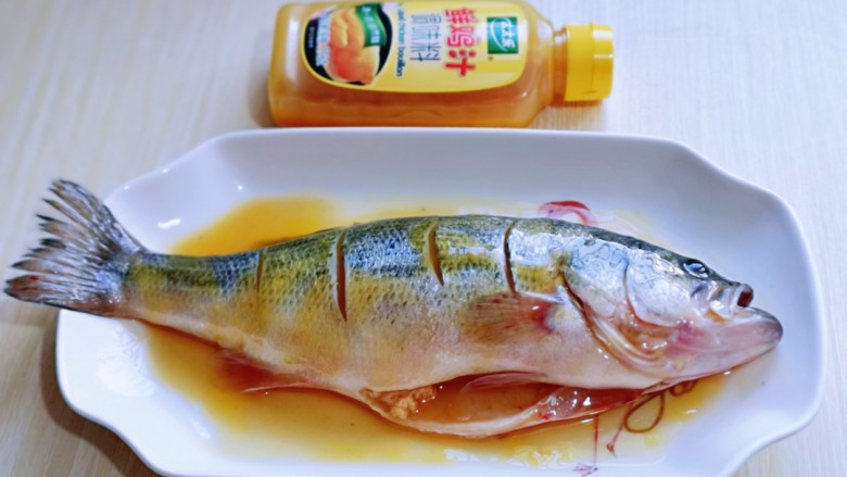 补充蛋白就靠它～鸡汁烧鲈鱼,将鸡汁涂抹均匀，腌制15分钟。