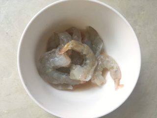 海鲜焗面,将虾装入小碗内，加1汤匙料酒腌一会
