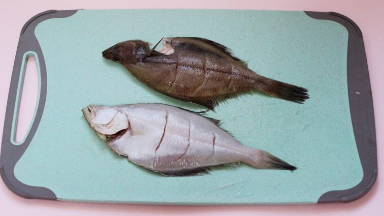 补脑养生的清蒸比目鱼,用厨房纸把比目鱼的水擦干净后，用刀把比目鱼划出口，以便方便腌制入味。
