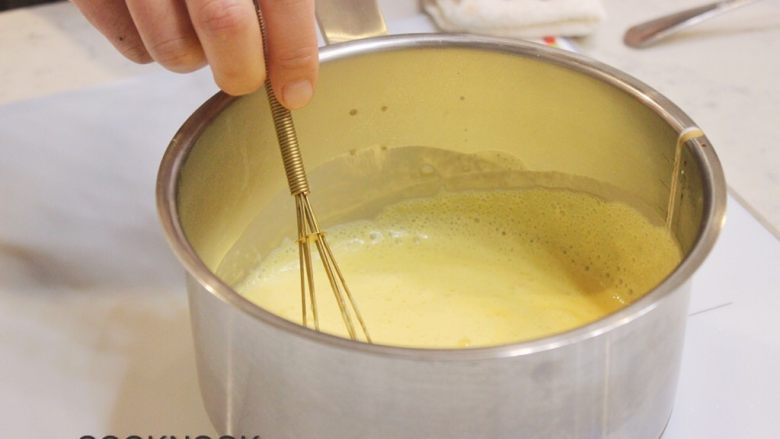 英式奶油酱白巧克力舒芙蕾,打蛋器搅拌均匀.中大火加热, 持续搅拌,直到酱汁能够沾上汤匙背面.立刻关火