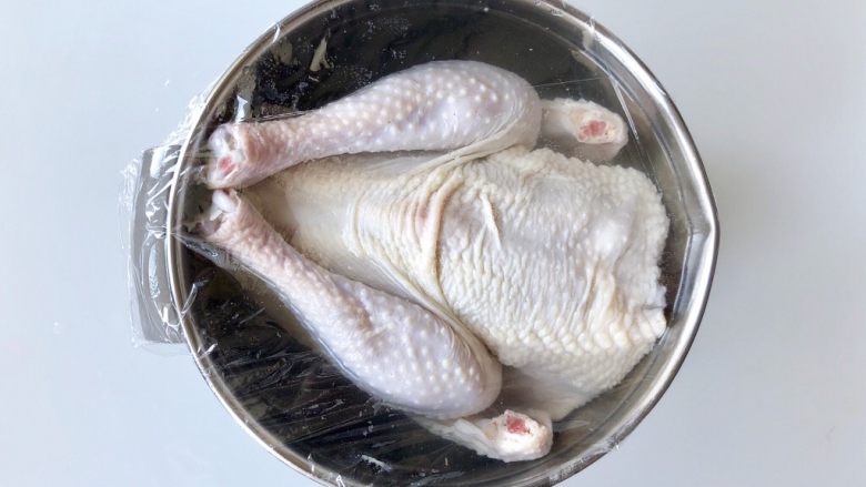 柠香蜜汁烤鸡,把鸡浸入盐水中，盐水没过鸡身，然后盖上保鲜膜，放入冰箱浸泡两个小时。