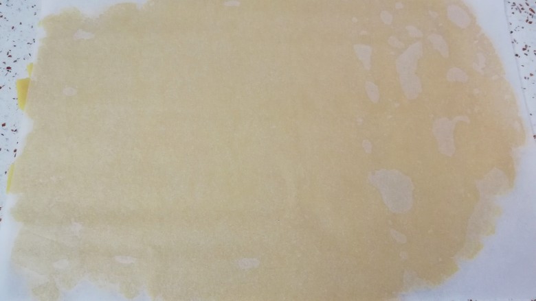 姜饼人饼干,准备好油纸，铺在台面上，放上变硬的面团压扁，上面再盖上一张油纸，擀至3mm厚度即可。