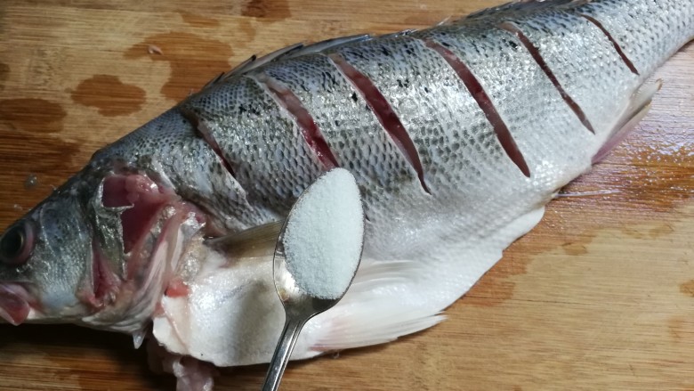 清蒸海鲈鱼,一小勺盐均匀涂抹鱼里外，腌制半小时