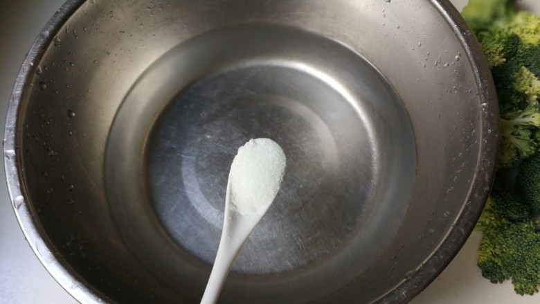 蒜泥拌西兰花,盆中放入一小勺盐搅化