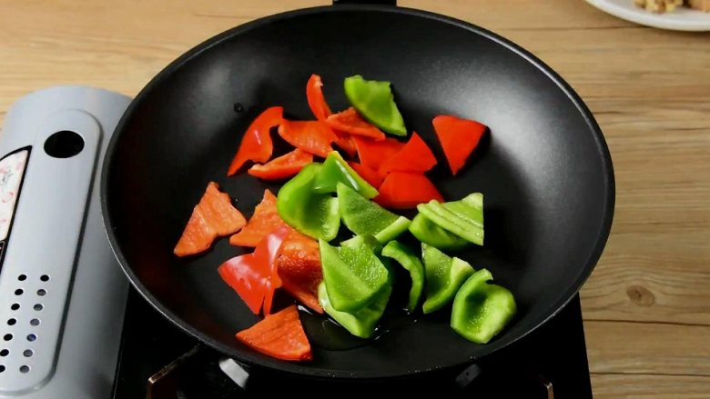 菠萝咕噜肉——水果入菜，一不小心却成了名菜,锅中倒少许油，将青红椒炒至表皮变软，盛出备用。