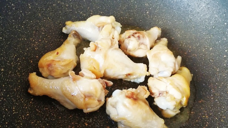 翅根香菇焖饭,炒锅内倒适量的食用油烧热，下入鸡翅根煸炒至表皮微微焦黄。
