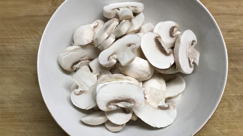蘑菇炒菜梗,蘑菇用软的刷子刷洗掉表面的的脏物，清洗干净后切成片。