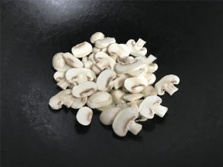 蘑菇炒菜梗,把切成片的蘑菇放入锅中。