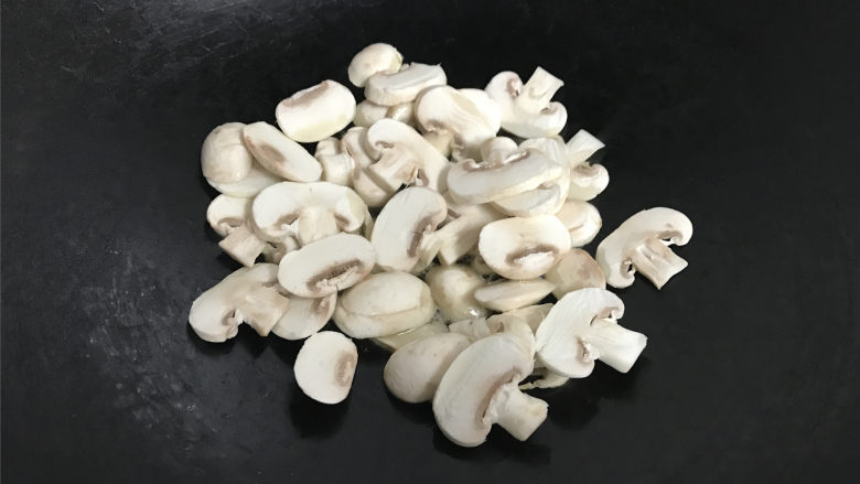 蘑菇炒菜梗,把切成片的蘑菇放入锅中。