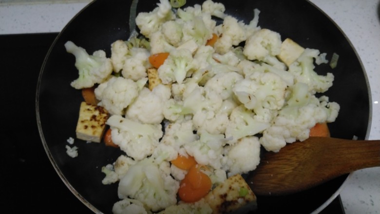 豆腐炒菜花,放入菜花、胡萝卜。