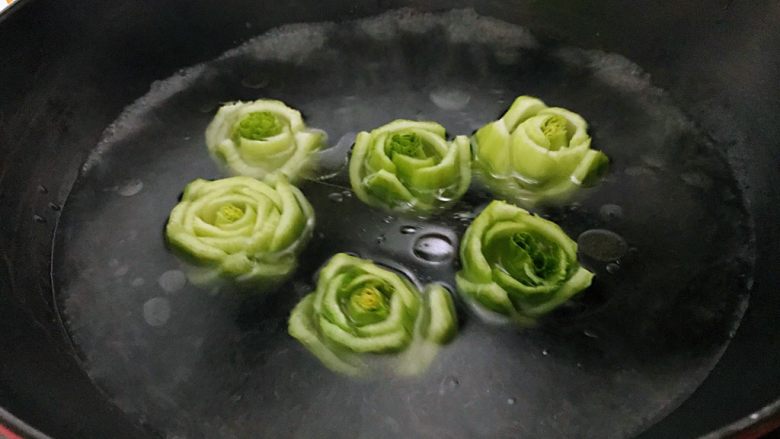 绿玫瑰花,放入绿色的玫瑰花焯水3分钟左右捞出，其间翻动花朵，保证从里到外都能熟。
