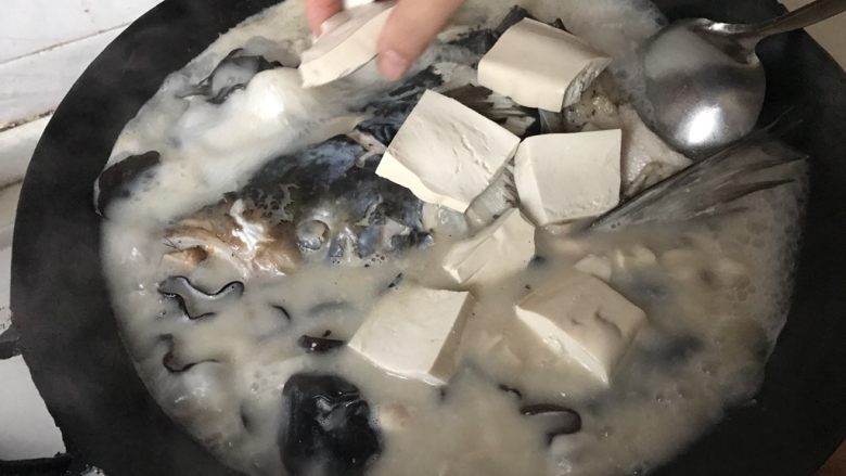 鱼头汤,放入豆腐。盖上锅盖，炖煮10分钟