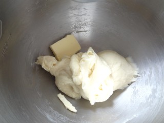  日式炼乳手撕包,加入软化好的黄油，开始继续揉面程序，同样低速成团，中速搅打