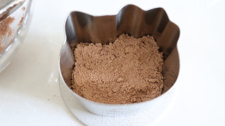 HelloKT蒸米糕，又萌又美味,全部筛完后，准备好模具，用到了慕斯模具，底部可以档一个平的盘子，然后用勺子挖出棕色的粉，到容器中。
