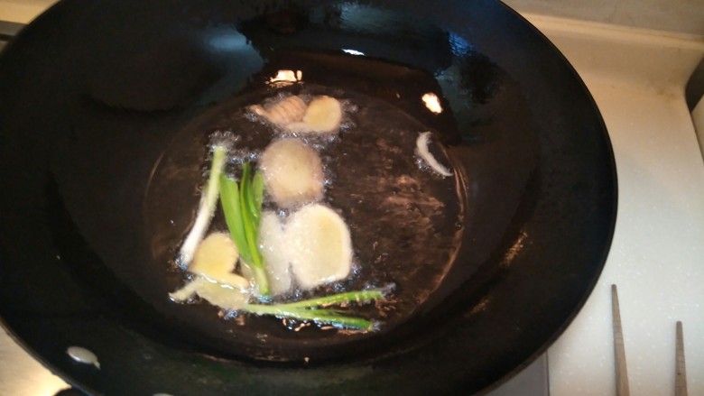 一道正经的菜——咸菜马江鱼,放姜放葱放入锅中煸炒。