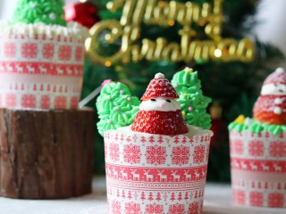 圣诞杯子蛋糕,草莓从头上三分之一的位置切断，挤白色奶油，再盖上，用黑芝麻点缀眼睛。胖胖的草莓🎅完成!