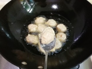 炸蛋黄酱圆子,锅中放入一大碗豆油烧热，用勺子接住手中挤出的肉糊放入锅中
