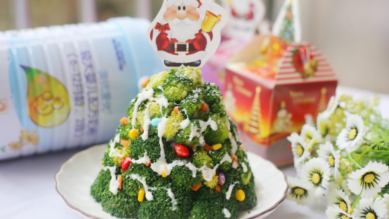 【圣诞美食】西兰花土豆泥圣诞树,再用奶粉加适量水调成浓稠的奶，放入裱花袋中，浇到圣诞树上。