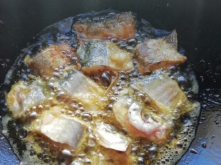 大蒜闷鱼,锅里放油待油烧热、逐块放入鱼块 炸至外脆里嫩、