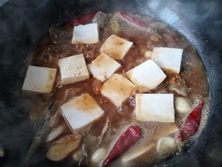 酱焖辫子鱼,炖一会儿后就可以将切片的豆腐平铺在鱼身上继续慢炖约20分钟，大火收汁即可。。