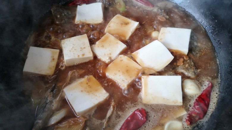 酱焖辫子鱼,炖一会儿后就可以将切片的豆腐平铺在鱼身上继续慢炖约20分钟，大火收汁即可。。