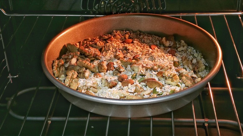 果仁燕麦能量棒,烤箱预热180度。把果仁燕麦混合物装入烤盘，入烤箱烘烤5分钟，晾凉。